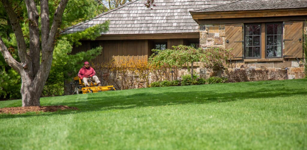 man mowing lawn with riding lawn mower