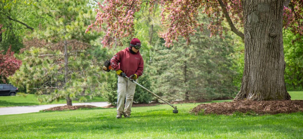 A Scott's Lawn Care Professional cutting weeds