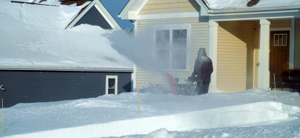 Person snowblowing their driveway after a winter storm
